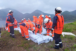 土のうを積み上げ水防工法を実施する消防団員（佐多地区）