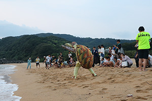 ウミガメの赤ちゃんを放流する参加者